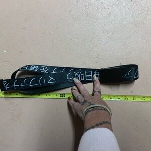 Black adjustable clip belt with white lettering on it. In great condition.